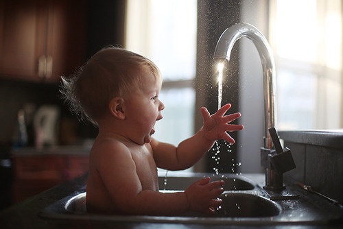 baby having bath in sink